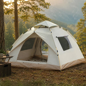 White pop-up tent in the woods with a lantern at sunset