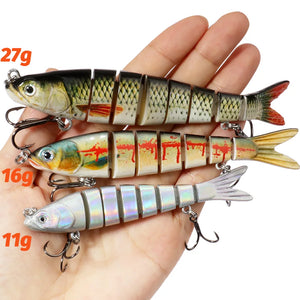 Three jointed swimbaits held in an open hand to show the 27 g, 16 g and 11 g sizes