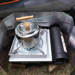 Folding wind screen in use at a campsite with a pot on the stove