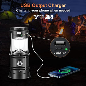 Black lantern charging a phone from its USB port by a campfire, with a YILIN logo