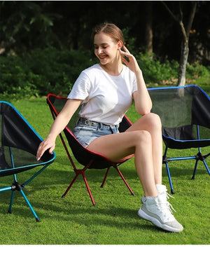 Woman sitting in a mesh moon chair on the grass