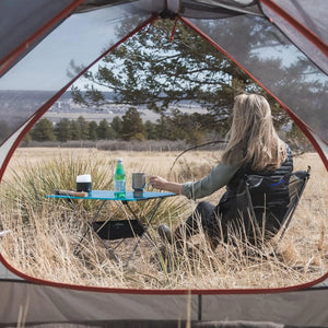 Woman in an ultralight chair seen from a tent door