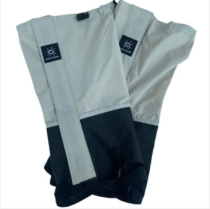Light gray and black gaiters folded flat, logo patch on the front strip