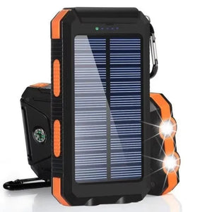 Orange TrailCell solar power bank with dual flashlights lit and compass on back