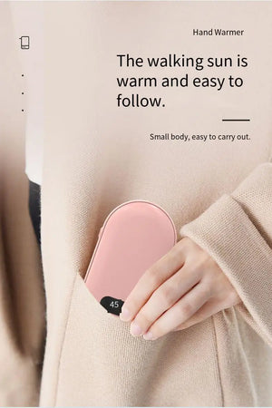 Pink rechargeable hand warmer slipping into a coat pocket, screen showing 45