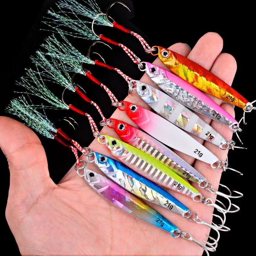 Seven metal jig lures in mixed colors with assist hooks, held in an open hand
