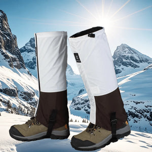 White and brown gaiters on hiking boots with snowy mountains behind