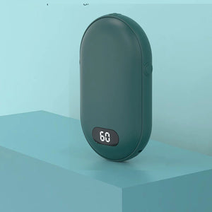 Green hand warmer standing on a blue block, side view with button