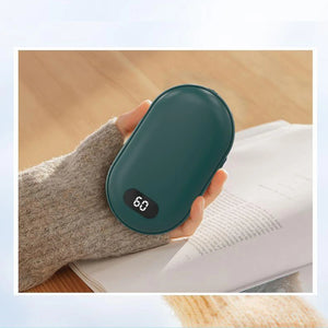 Hand in a knit sleeve holding a green rechargeable hand warmer showing 60 on the screen