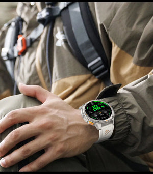 Silver smartwatch with white band showing green digital dial on a hiker's wrist