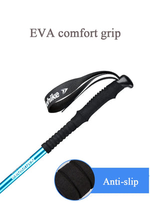 Close-up of the black EVA foam grip and nylon wrist strap on a blue trekking pole
