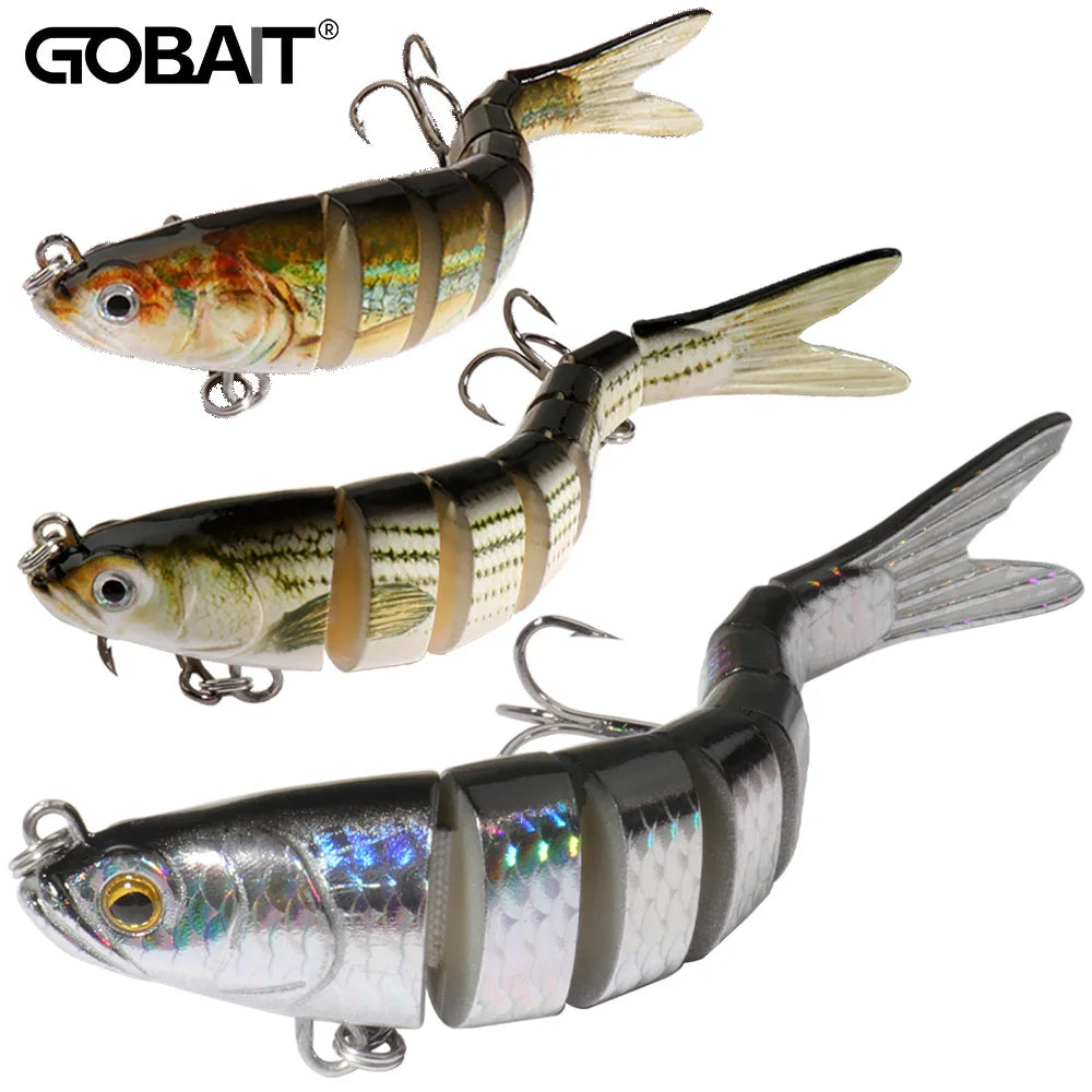 Two silver jointed swimbait lures with treble hooks on wet gravel