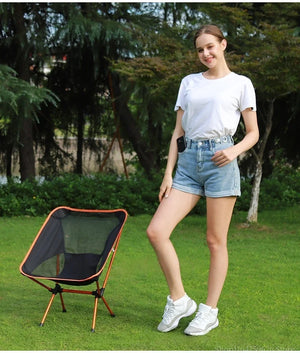 Woman standing next to a mesh moon chair