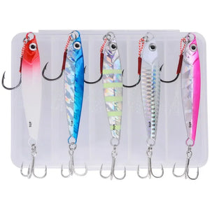 Five metal jigs with assist hooks in a clear lure box