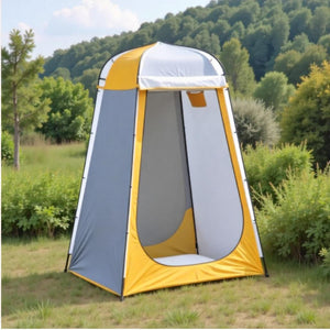 Yellow and gray privacy tent standing in a grassy field with the door open