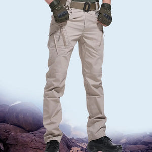 Khaki cargo pants with zip hip pockets, worn with gloves and black boots on rocks