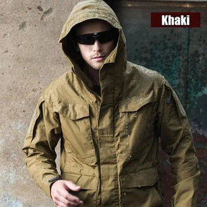 Khaki StealthForge field jacket worn with the hood up, water drops beading on the fabric