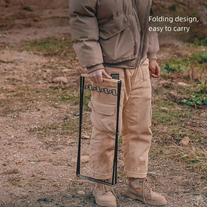 Person carrying the folded trash bag stand by its wood handle