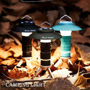 Three mini camping lanterns lit on fall leaves: black, dark green and sky blue