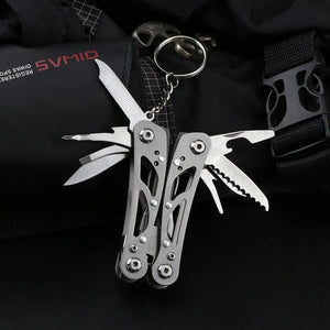Small silver Adventure Buddy on a key ring with its fold-out tools open, on a black pack