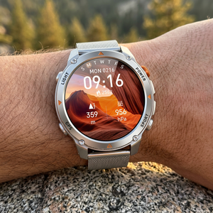 SummitNav GPS smartwatch with a silver mesh band on a wrist at a trail overlook at golden hour