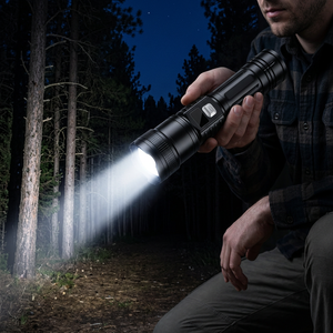 Hand holding the black zoom flashlight on a dark forest trail at night, its bright beam lighting the path ahead
