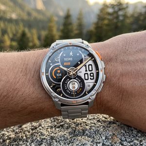 TrailCore outdoor smartwatch with a silver steel link bracelet on a wrist at a trail overlook