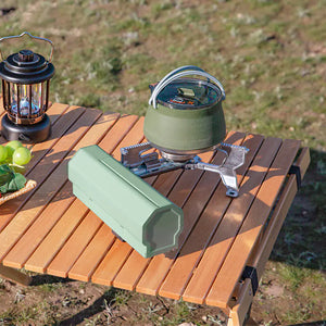 Green AdventureChef stove heating a green kettle on a wooden camp table