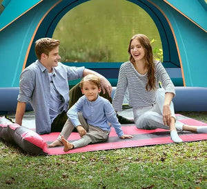 Family sitting in front of an open pop-up camping tent